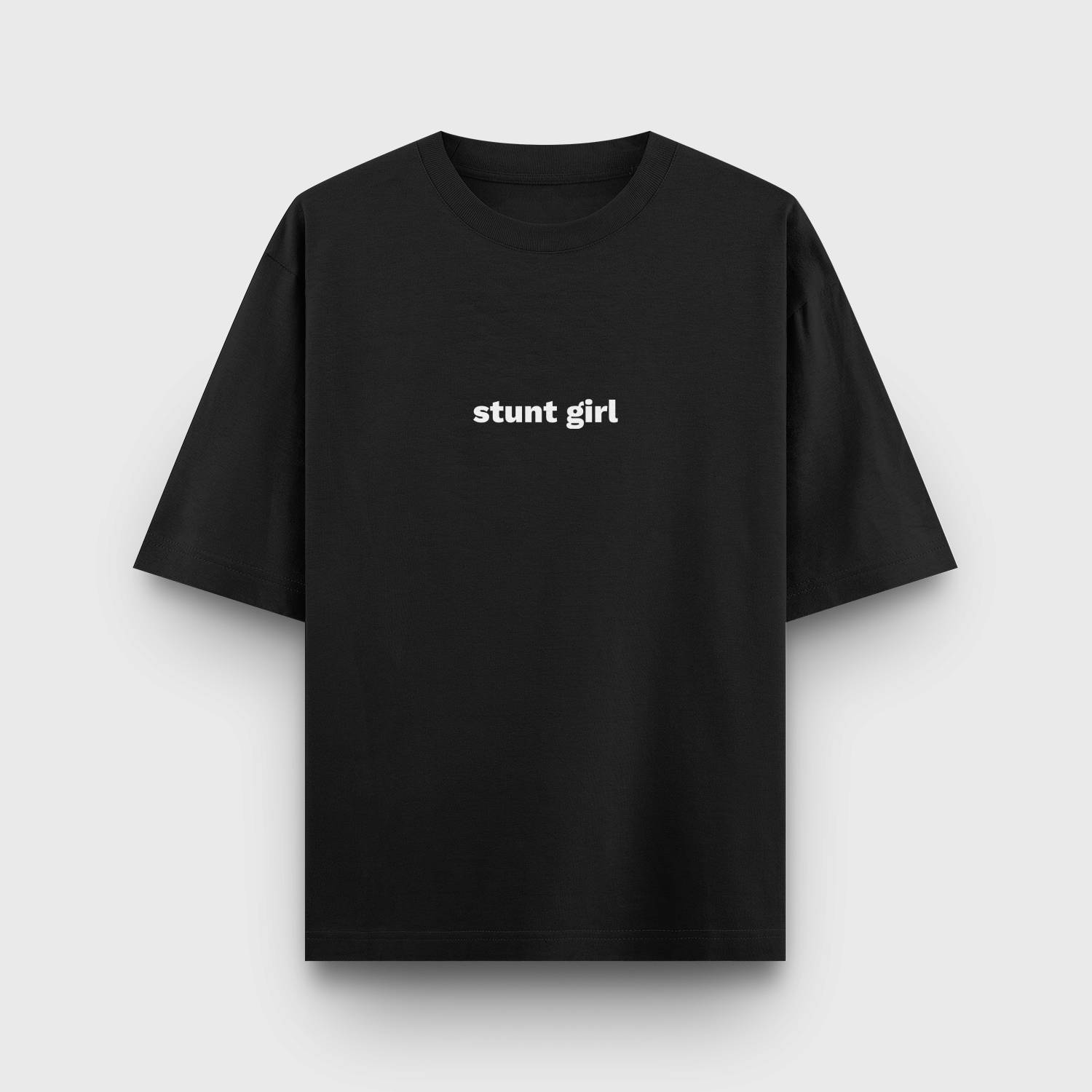 Black oversized t-shirt with "STUNT GIRL" printed in white minimalist text at the center.